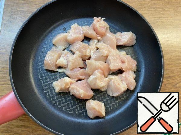 Cut the chicken fillet into pieces, wash it under running water, and put it in the pan where the dish will be prepared.