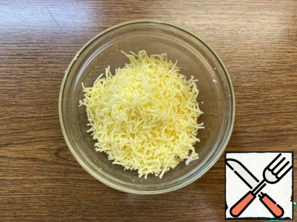 While the dish is ready, grate the cheese on a fine grater (you can take any semi-hard or hard to taste, for example, Parmesan).