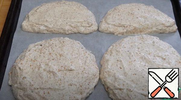 On parchment paper, draw a template (2 circles and 2 semicircles with a diameter of 18 cm) and lay out the dough, visually dividing it into three parts (300 grams each). Bake the cakes for 35 minutes, and then leave to cool completely.