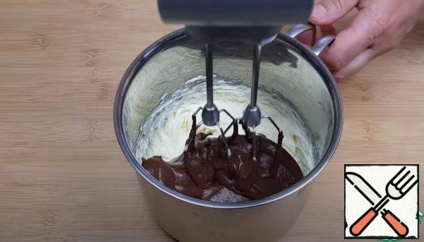 Beat 150 grams of soft butter, gradually adding the chocolate mass. The cream is ready.