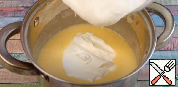 Gradually add sour cream and put the saucepan on the stove. Cook the cream over medium heat until thick.