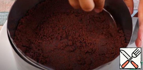 We collect sour cream. Put 1/3 of the crumbs on the bottom, flatten and seal. Next, distribute another 1\3 crumbs on the sides (use a spoon to make the sides 4 cm high).
