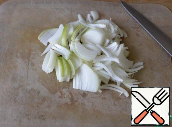 Pour vegetable oil into the pan. Onions are cleaned, cut at random, I have feathers. Put on a preheated frying pan with oil.