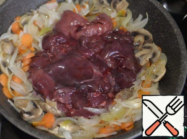 Vegetables with mushrooms are pushed in the pan to the walls, freeing the middle, put the liver.