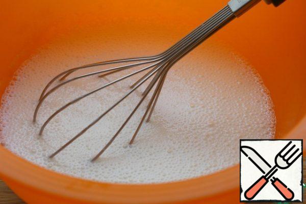 Kefir, 200 g of sugar, baking powder mix with a whisk.
Pour in the vegetable oil, egg and mix.