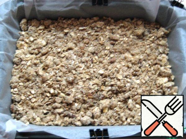 In a baking dish (the size of my form is 18 x 26, the bottom is covered with parchment), put half the crumbs, flatten and slightly tamp.