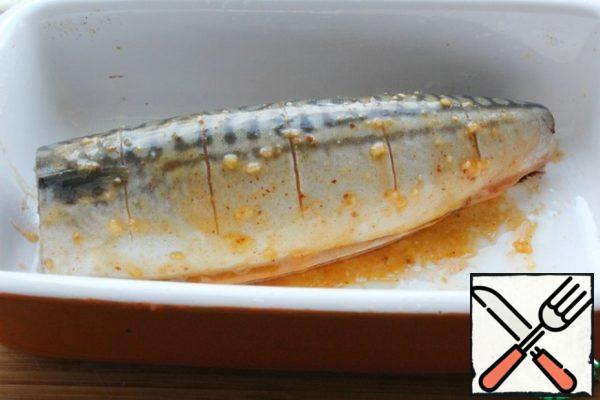 RUB the mackerel, cut it and grease it on all sides and inside with the garlic marinade.
Grease the form with vegetable oil, put the mackerel in the form.