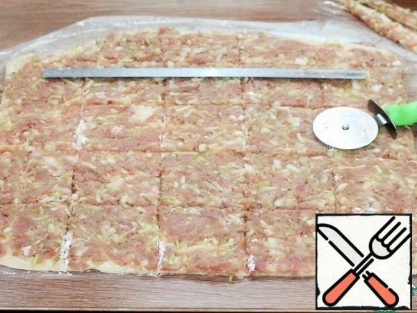 Distribute the filling evenly over the dough. I first spread out the filling with a spoon, and then carefully leveled it with a rolling pin and got an even layer.
Cut the layer with the filling into 8*8 cm squares.