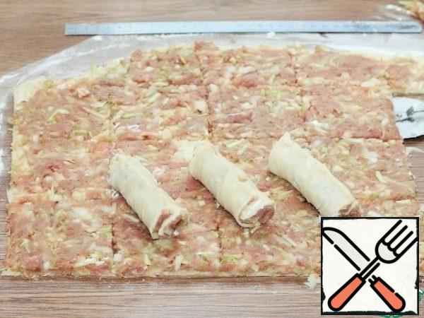 Fold the squares into rolls. The edge of the rolls is carefully pinched and dipped in flour.