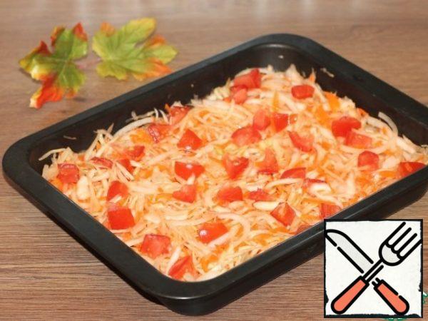 Take a baking dish (I have 28 * 22 cm) and grease the bottom with vegetable oil. Spread the cabbage with carrots. And add the chopped vegetables; onion-thin half-rings, tomato-small cubes and pressed garlic. Gently mix.