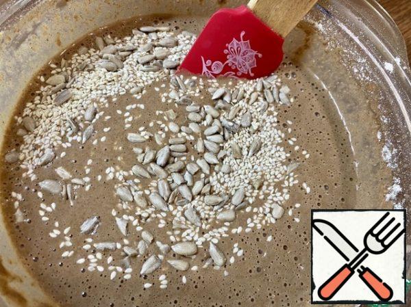 Add 1 tbsp of peeled sunflower seeds and sesame seeds, stir with a spatula.