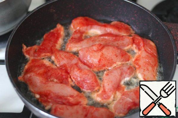 Then lay out the chicken fillet seasoned with salt and spices. Fry the fillet until Golden brown. Everyone determines the degree of tinting of the top layer of fillet independently.