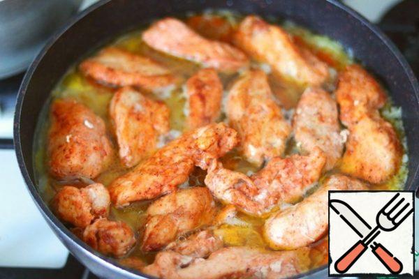 Next, put the pieces of fried chicken fillet until half-cooked. Cover the pan, reduce the heat to low, and cook until the rice is ready.
