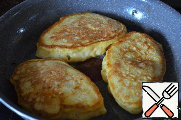 Turn it over with a spatula, cover with a lid, and fry for another 2 minutes, the heat is lower than average. Hot spread on a platter. For frying, re-pour and heat the oil, so fry all the pancakes.