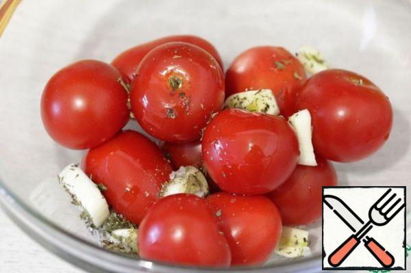 Put the cherries and garlic in a bowl, add the herbs of Provence, season with salt, pepper and drizzle with oil.
