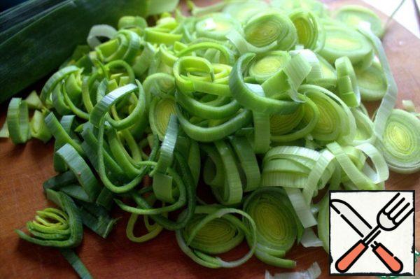 Cut the middle and white parts into rings and put them out in a frying pan.