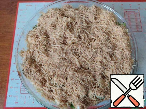 Pour the prepared filling on the cabbage and sprinkle everything on top with a mixture of cheese and breadcrumbs.