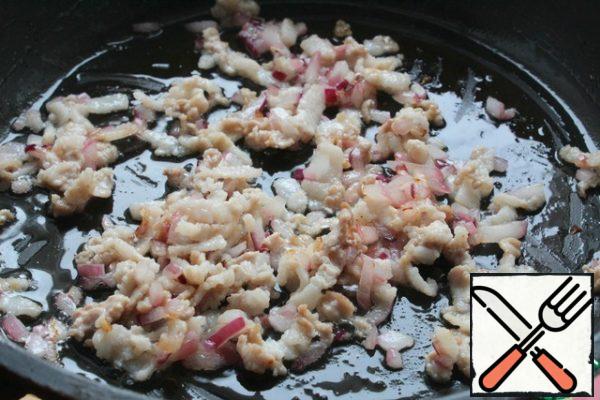 In a preheated frying pan with oil, fry the onion (cut into cubes) with bacon.
Cool.