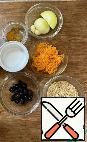 Prepare the ingredients for further cooking: rice, grated raw carrots, onions, garlic, salt, spices, olives, sunflower oil.