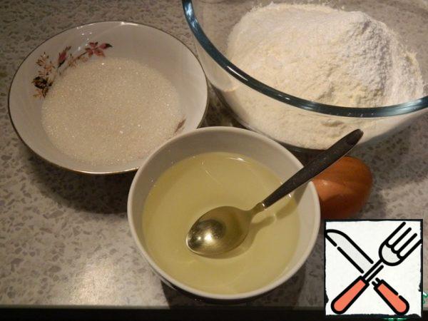 Take the products for the dough: flour, sugar, butter, egg. Mix the flour with sugar, add the egg and butter, stir with a spoon, then RUB the resulting mass with your hands into crumbs.