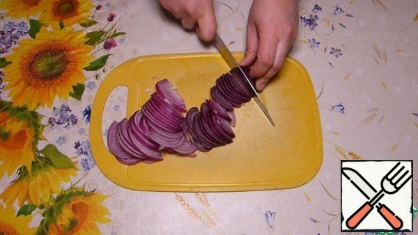 Cut the onion into thin half-rings.