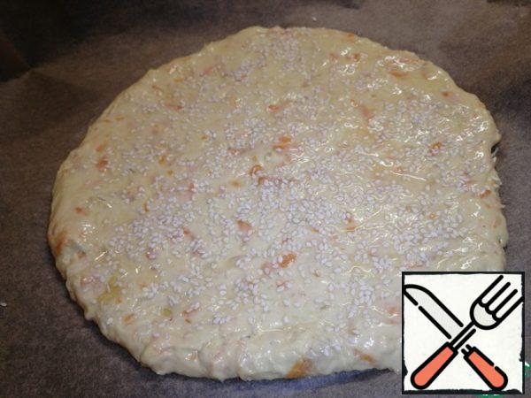 Cover the baking sheet with baking paper. One part of the dough is sent to the baking sheet and pressing the hand we give the shape of a circle. The thickness of the tortilla should be approximately 1-1. 5 cm. Brush with egg and sprinkle with sesame seeds.