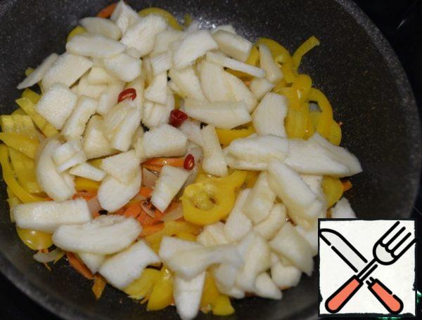 We clean the zucchini, cut it into strips or cubes, and put it in a frying pan. Also put rings of hot pepper to taste. Stir.