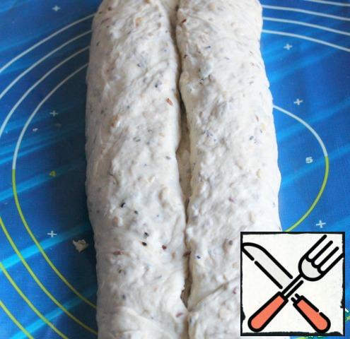 Form 20x25 grease with vegetable oil. I lined it with parchment.
Put the dough on the table, slightly squeezing with your hands, make a rectangle about 22 cm long.
Fold the long ends to the center a couple of times.
Pinch the ends.