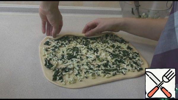 Spread half of the filling on the dough, evenly distributing.