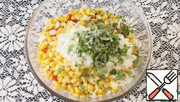 Collecting salad. In a bowl, pour cucumbers, bell peppers, canned corn, onions, tomatoes, herbs, lemon juice, vegetable oil and salt to taste. Mix everything well.