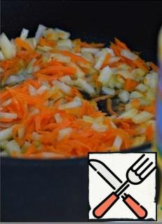 In a deep frying pan or saucepan, heat the sunflower oil. Put the carrots grated on a large grater in the pan. 