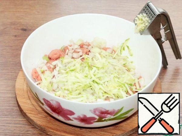 To the minced meat, add finely chopped onion, pressed garlic and grated zucchini. Grated zucchini is a small residue from the slicing of the zucchini, edge (0,4 Cup).