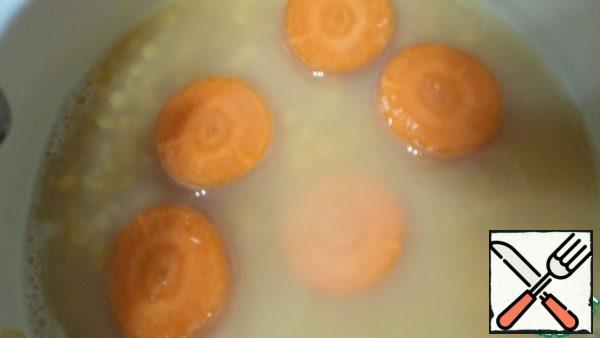 Cook the peas in the same water where they were soaked, add coarsely chopped carrots (I have circles 1.5 cm thick). Cook until the peas and carrots are ready.