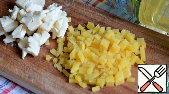 Pour in the broth, milk and cream, stir, and let boil. Add pieces of processed cheese and Gouda cheese and cook for 3 minutes.