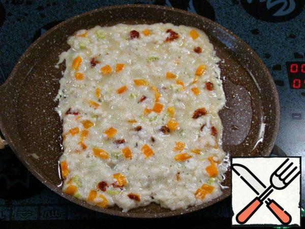 Pour half of the rice filling evenly into the middle of the pan. Use a spatula to carefully form as smooth edges as possible.
The width of the rice filling should be equal to the length of the sausages.
