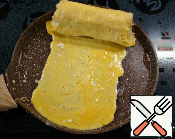 Pour another 1/4 of the omelet, also forming the edges and width. When the omelet is ready, roll up the roll.