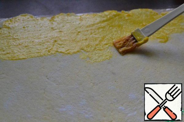 Brush the dough with the beaten egg yolk.
