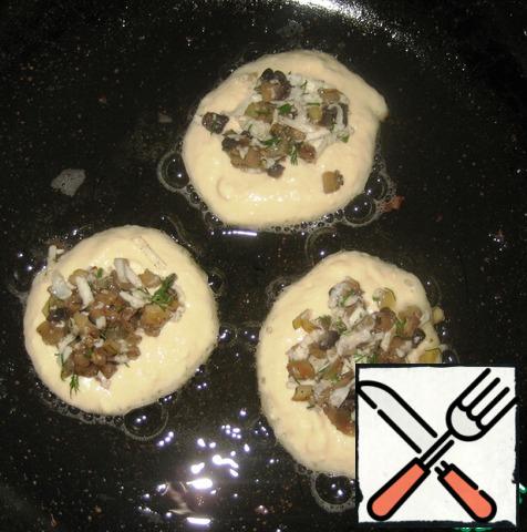 Heat the vegetable oil in a frying pan, spoon the dough (about 1 tbsp), put the mushroom filling (about 1 tsp) on top in the center.