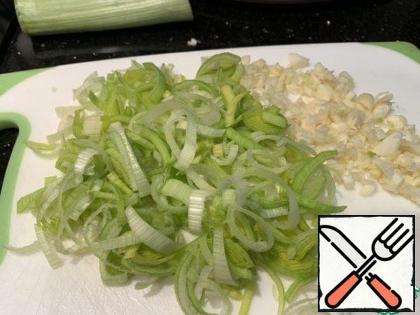 Finely chop the garlic and cut the leeks into thin half-rings.