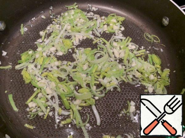 In a saucepan with a thick bottom, heat 1 tablespoon of vegetable oil, put the leeks and garlic, and fry until transparent.