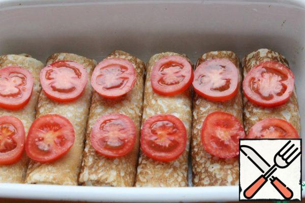 Top with thinly sliced tomatoes.
If you don't have Parmesan, grate the hard cheese and sprinkle on the pancakes.
The oven is preheated to 190.
Bake for 20 minutes in a ceramic mold.