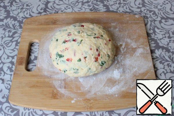 I begin to knead the dough for bread. At the beginning, I mix it with a spoon.
Then I add the remaining flour and collect the dough in a tight ball. For the convenience of kneading, you can slightly lubricate your hands with vegetable oil.
You do not need to knead the dough for a long time. The ingredients just need to come together in a homogeneous lump.