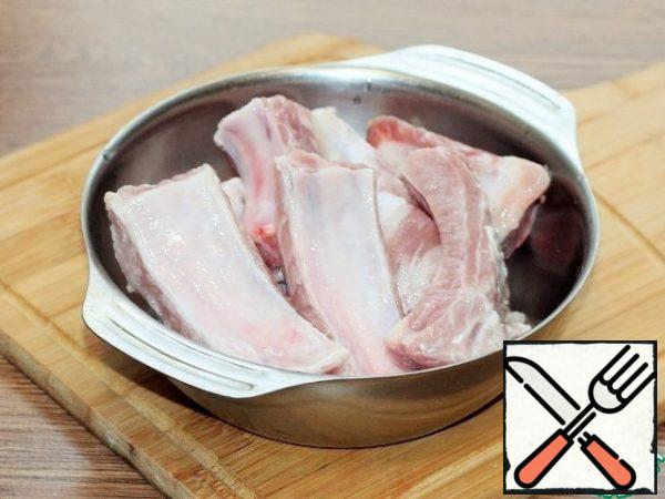 Wash the pork ribs, dry them and cut them into portions. Put the pork in a saucepan (3 liters) and fill it with water (2.5 liters). Over medium heat, bring the broth to a boil and remove the foam. When the separation of the foam is stopped, the broth can be strained.