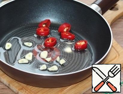 Fry garlic and hot pepper in sunflower oil. Then we remove the vegetables and leave the oil.