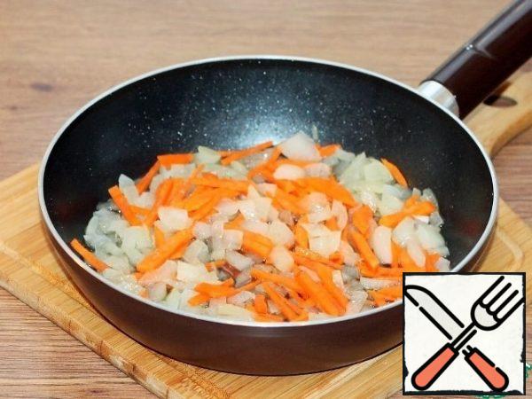 In garlic oil, fry the onion until transparent. Add the carrots and fry them for 2 minutes.