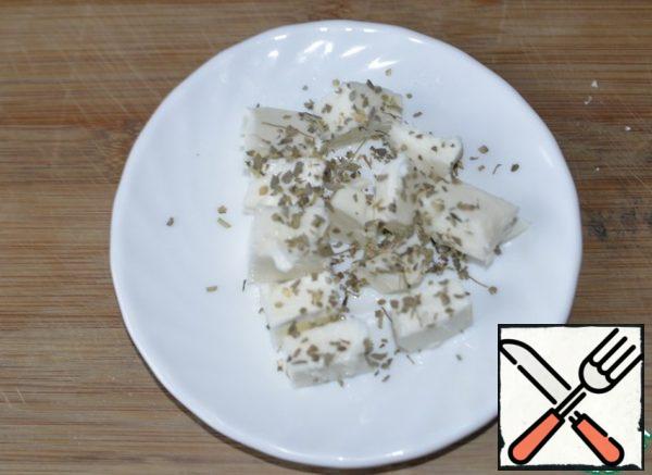 Take the feta, or the fitaki cheese. Expect that the cheese is salty. Cut into cubes, sprinkle with dried Basil or your favorite herbs.