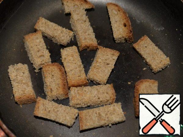 Cut a slice of bread into pieces and dry it in a frying pan.