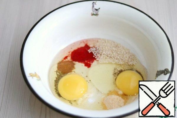 In a separate bowl, combine the entire set of spices according to the recipe: ginger powder (1/2 teaspoon), a mixture of Provencal herbs (1 teaspoon), sweet paprika (1 tablespoon), garlic powder (1 teaspoon), sesame (1 tablespoon), chicken egg (2 PCs.), salt and ground black pepper to taste.