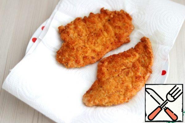 Next, put the schnitzels on a paper towel to remove excess oil.