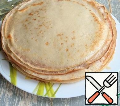 Bake pancakes in a frying pan, if necessary, smearing it with sunflower oil. Brush each ready-made pancake with melted butter.